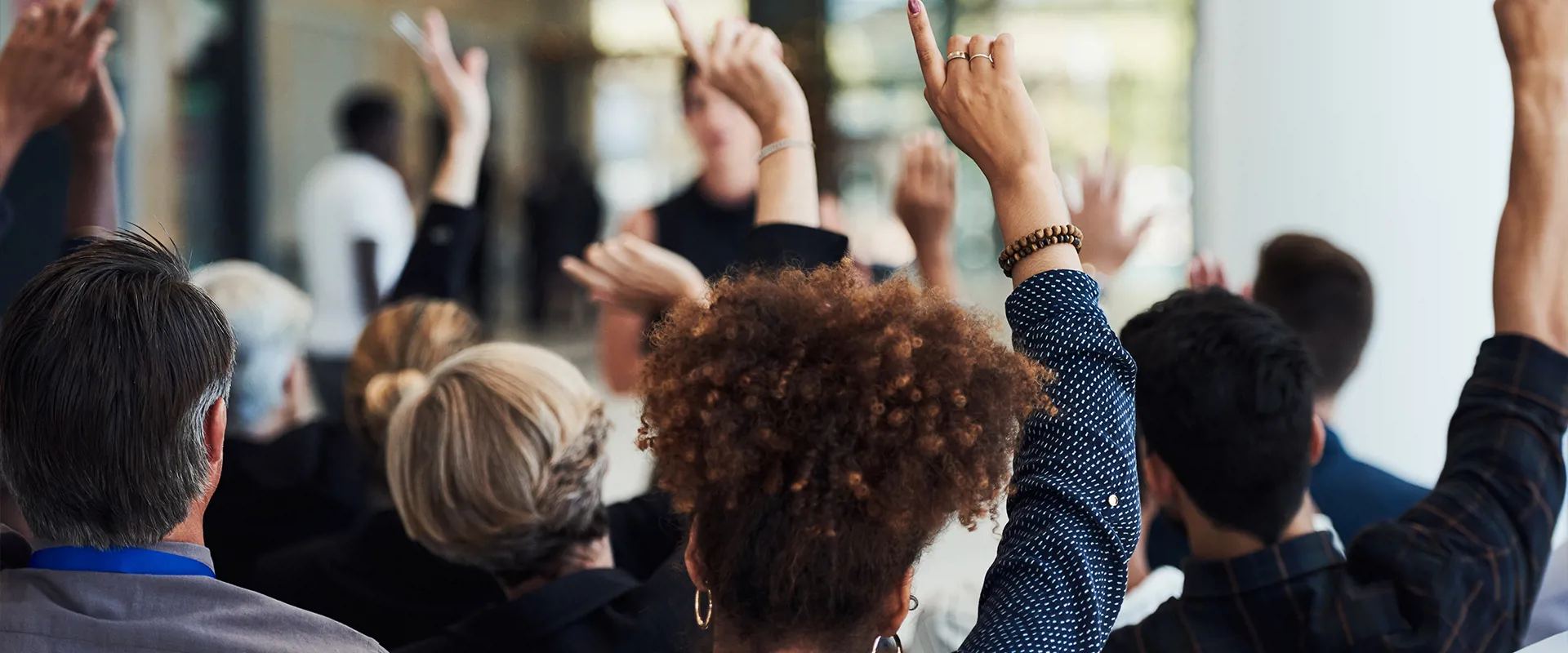 Employees raising hands to ask a question during the First Annual Employee Briefing