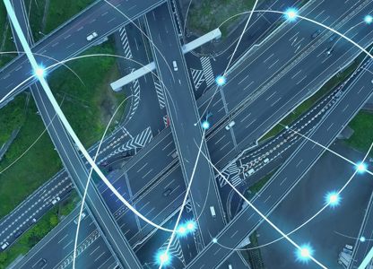 Aerial view of a motorway interchange, overlaid with glowing digital network lines