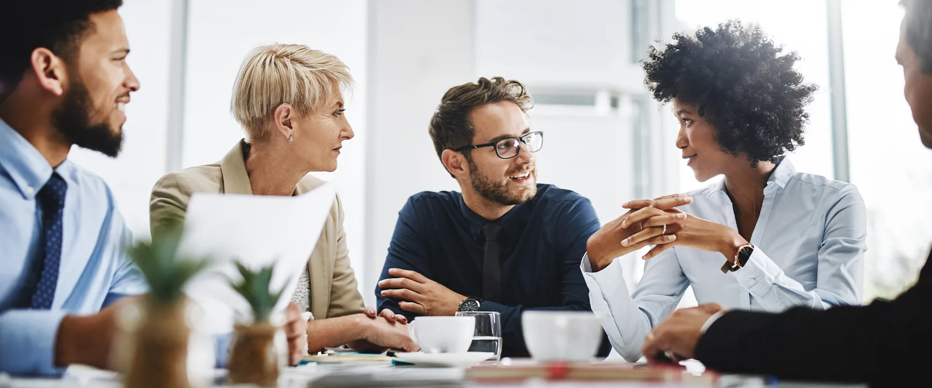 Procurement specialists discussing a corporate newsletter in the office