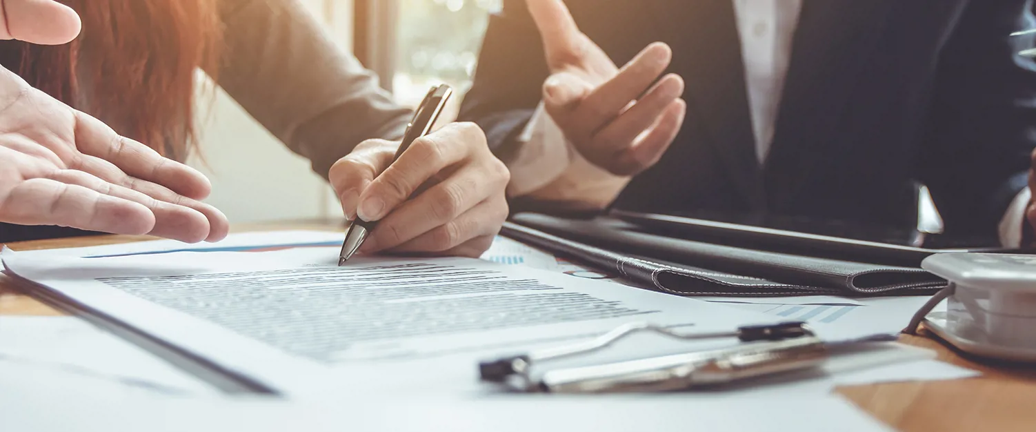 Procurement professionals making notes in a meeting in the office